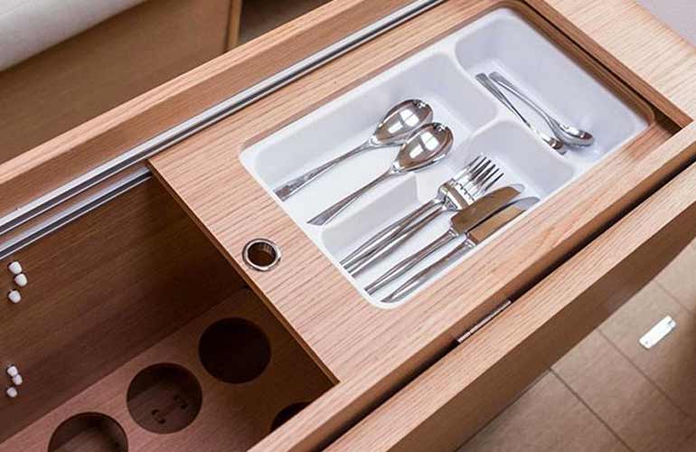Dufour 350 il portaposate e porta bottiglie nel corpo del tavolo della dinette