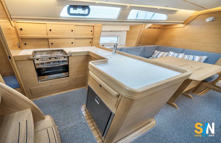 Hallberg Rassy 370: cucina e dinette – Disposizione a L con ampi spazi di lavoro, piano in Corian e dinette luminosa con divano a U.